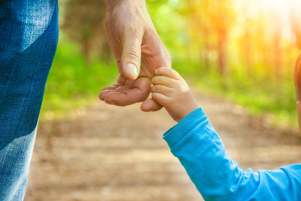 the parent holding the child's hand with a happy background - Photo, image