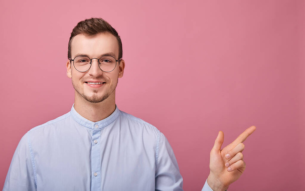 decent young man in blue shirt and computer glasses posing on pink background  - Fotografie, Obrázek