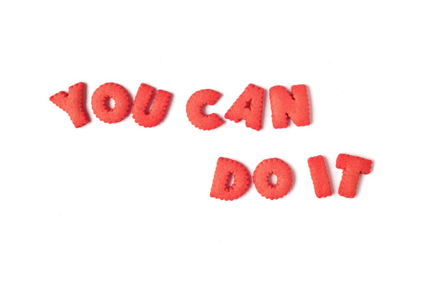 Слово you CAN DO IT пишеться з печивом у формі червоного алфавіту на білому тлі
 - Фото, зображення