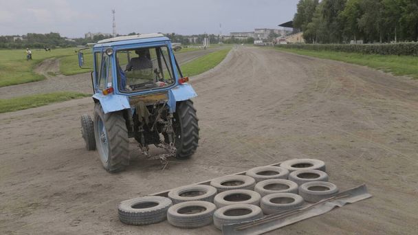 Wheeled tractor blue dub track racecourse old car tires - Photo, Image