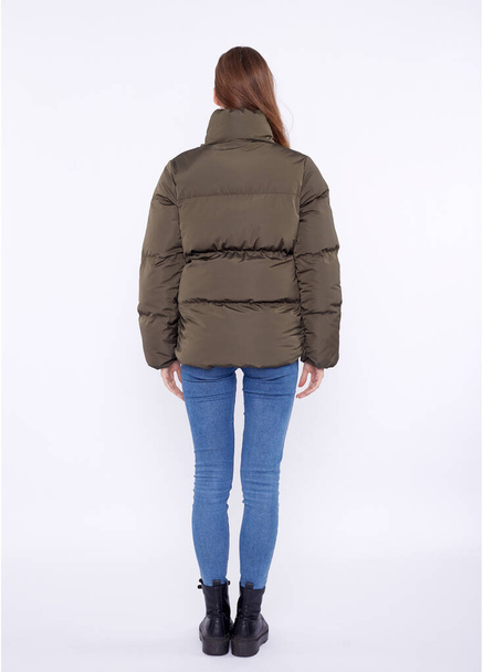 Young girl in a khaki down jacket isolated on a white background. - Foto, Imagen