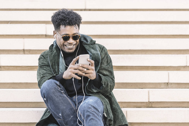 black man listening to music with earphones - Photo, Image