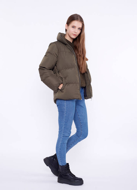 Young girl in a khaki down jacket isolated on a white background. - Zdjęcie, obraz