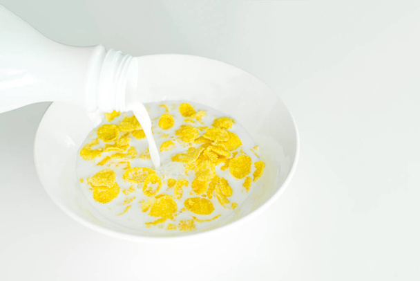 δημητριακά με γάλα σε λευκό πιάτο για πρωινό, χώρος για κείμενο, απομόνωση - Φωτογραφία, εικόνα