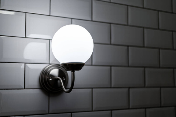 Ball shaped outdoor wall lamp on white tiled wall. exterior lighting. - Photo, Image