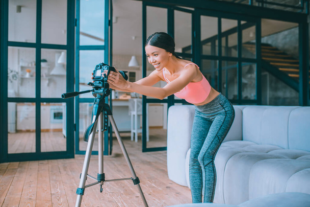 Fitness blogger fixing camera before making video - Foto, immagini