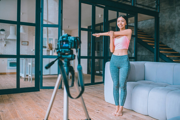 Young fitness blogger filming her favorite stretching - Foto, immagini