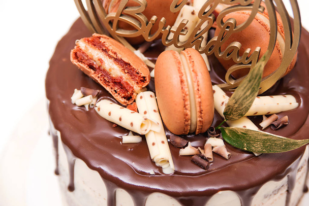 Bolo de aniversário decorado com macaroons dourados, vista superior. Elegante bolo nu coberto por chocolate
.  - Foto, Imagem
