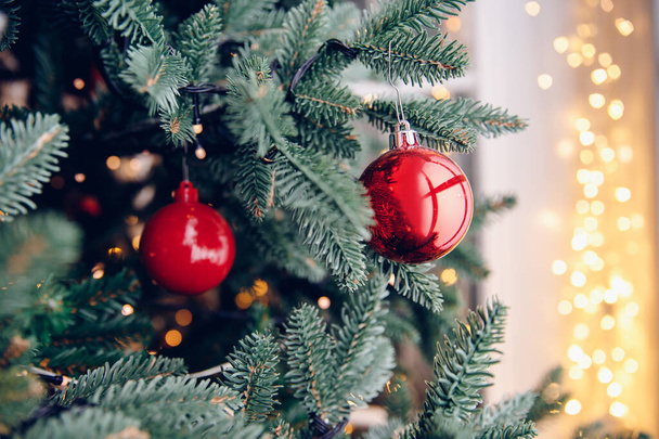 Χριστουγεννιάτικο δέντρο διακοσμήσεις κόκκινες μπάλες και αστέρι, με bokeh φως - Φωτογραφία, εικόνα