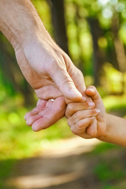 il genitore che tiene la mano del bambino con uno sfondo felice - Foto, immagini