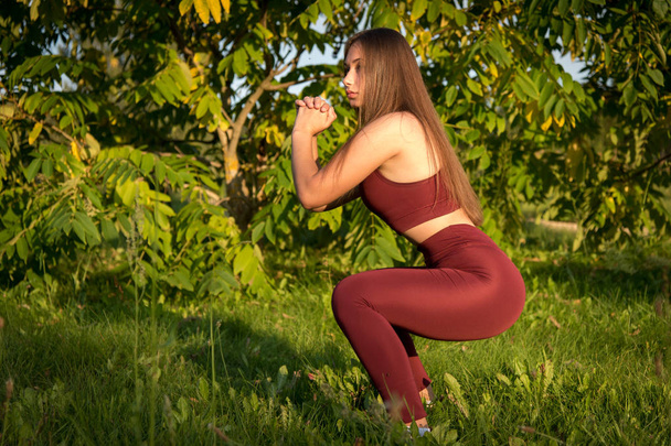 Молодая женщина занимается фитнесом на открытом воздухе. Образ молодой женщины, занимающейся фитнесом на природе
. - Фото, изображение