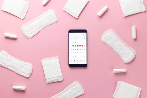 Tampons, feminine sanitary pads and gadget on a pink background. Hygienic care on critical days. menstrual cycle. Caring for womens health. Monthly protection. Flat lay, top view, copy space - Fotó, kép