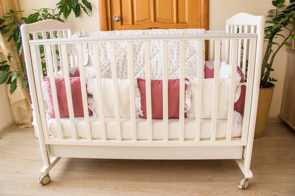 Baby bed crib with white and Burgundy color pillows with laces - Photo, Image