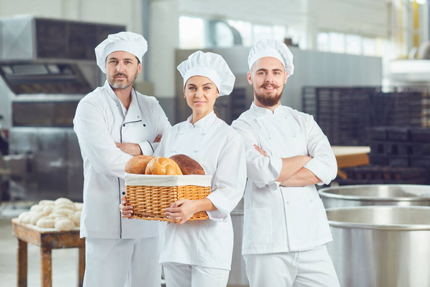 A group of bakers smiles at the bakery - Valokuva, kuva
