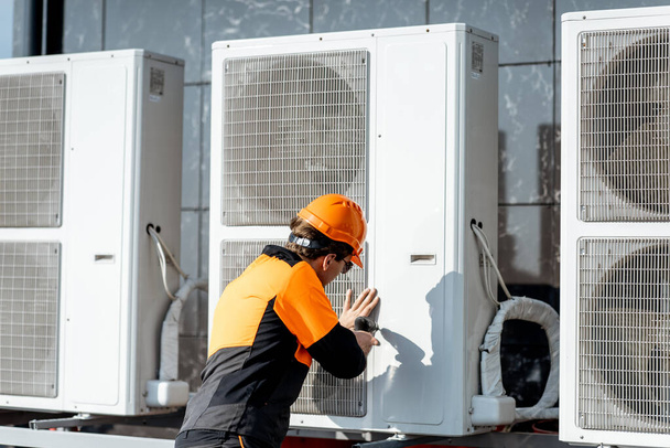 Workman che installa l'unità esterna del condizionatore d'aria
 - Foto, immagini