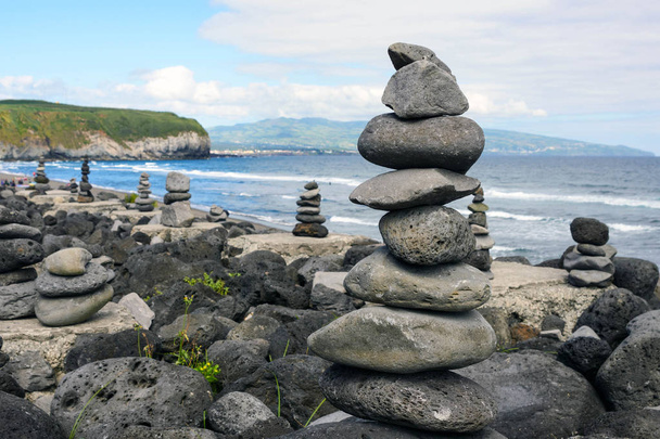 Pilha de pedras zen na praia.Cairns na bela praia do mar da Praia do Areal de Santa Barbara, ilha de San Miguel, Açores, Portugal
. - Foto, Imagem