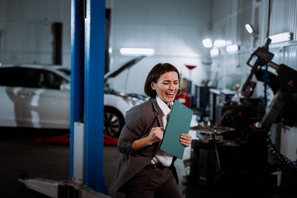 Mulher gerente elegante em um terno em um automóvel de serviço desfrutar animado na frente da câmera
 - Foto, Imagem