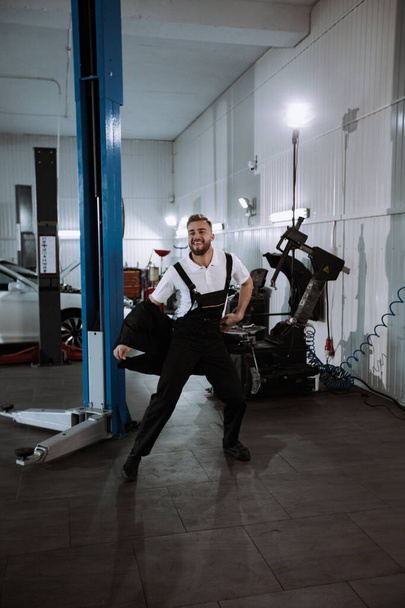 Atraktivní mechanik v moderním servisním centru, který legračně tancuje před kamerou, si dává pauzu od práce - Fotografie, Obrázek