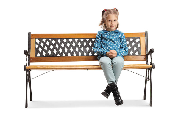 Little girl sitting on a bench and looking at the camera - Foto, Imagem