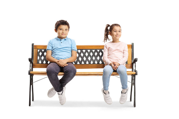 Niño y niña sentados en un banco y sonriendo
 - Foto, imagen
