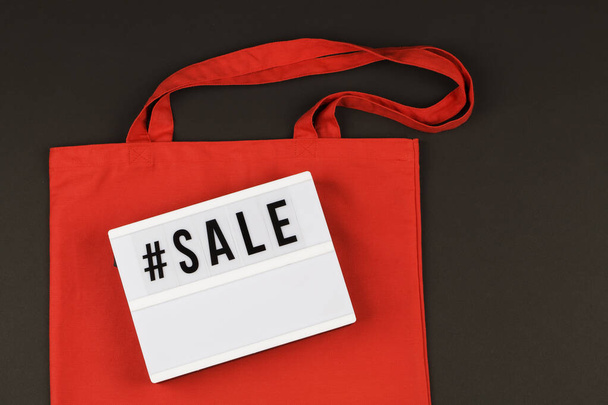 eco κόκκινο φυσικό τσάντα και lightbox με την πώληση κειμένου σε μαύρο φόντο - Φωτογραφία, εικόνα