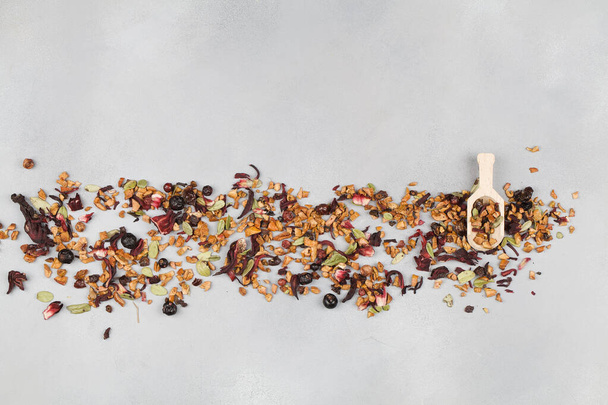 aromatic dry tea with fruits and petals with spoon on blue background - Fotografie, Obrázek