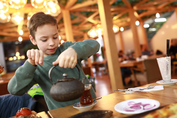 Boy pouring tea into turkish glass - Foto, imagen