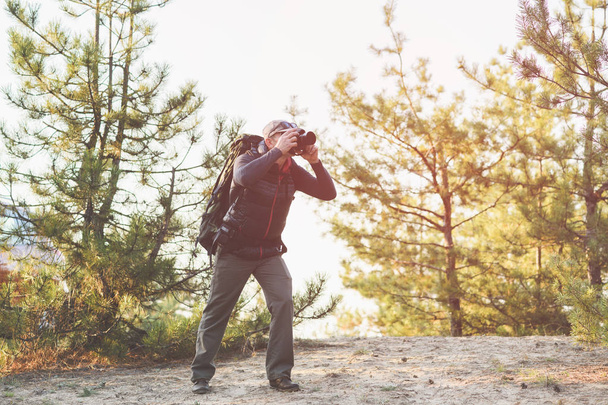 Senior man taking photo by camera in forest - Photo, Image