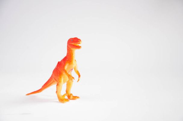 Orangener Dinosaurier. Kinderspielzeug aus Plastik. auf weißem Hintergrund - Foto, Bild