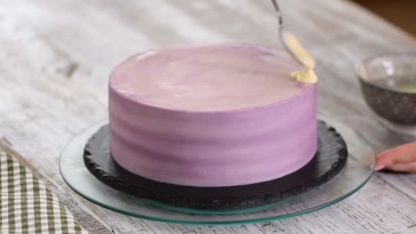 Hände Konditor bereitet einen Kuchen, gießen weiße Schokolade Glasur auf den Kuchen. - Filmmaterial, Video