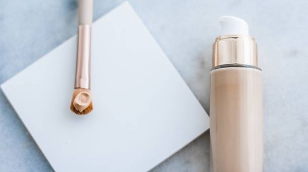 Бутылка для макияжа и контурная щетка на мраморе, макияж
 - Фото, изображение