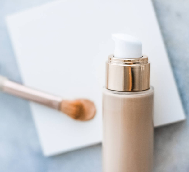 Make-up foundation fles en contouren borstel op marmer, make-up - Foto, afbeelding