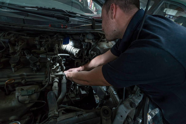 Automechanik pracující na automobilovém motoru v mechanické garáži. Autoservis. - Fotografie, Obrázek