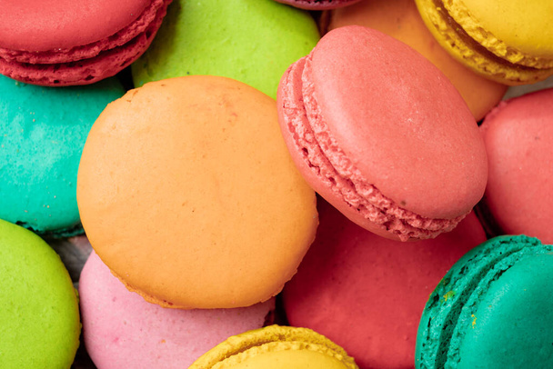 A lot of french colorful macarons on a pink background - Fotografie, Obrázek