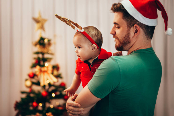 Playful father showing the Christmas tree to his baby son - Foto, immagini