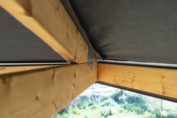 Dakspanten bedekt met een membraan op een vrijstaand huis in aanbouw, zicht van binnenuit, zichtbare dakelementen en spanplaten. - Foto, afbeelding