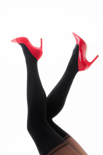 Ноги девушки в колготках с красными туфлями на белом фоне - Фото, изображение