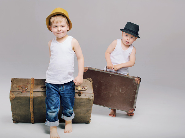 Brothers holding their heavy luggages - 写真・画像