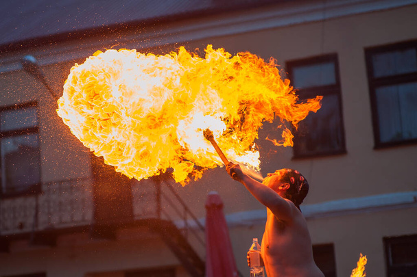 un joven arroja un fuego de su boca
 - Foto, imagen