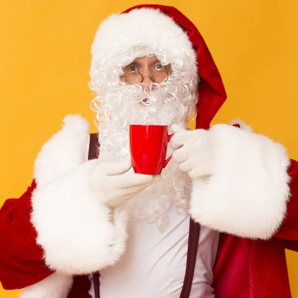 Knappe kerstman drinken hete koffie en snuiven smaak - Foto, afbeelding