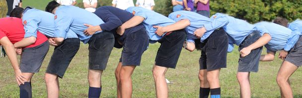 muchos chico con scout uniforme jugando a saltar rana al aire libre
 - Foto, imagen