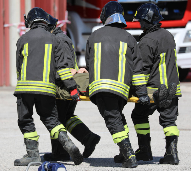 négy hordágy hordozók cipeli egy sérült személy - Fotó, kép