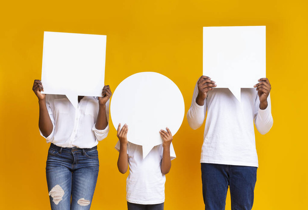Black family of three covering faces with empty speech bubbles - Photo, image