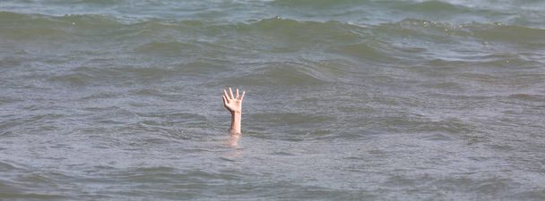 hand of the boy during the drowning in the ocean asking for help - Photo, Image