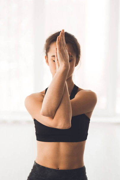 Donna con braccia incrociate che esegue esercizio di yoga
 - Foto, immagini