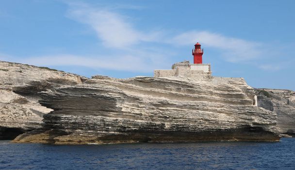 Mała starożytna czerwona latarnia morska w pobliżu miasta Bonifacio na Korsyce fr - Zdjęcie, obraz