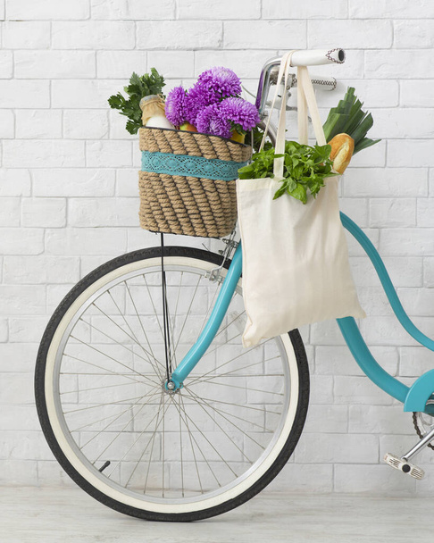 Eco vriendelijke fiets versierd met wilde bloemen en boodschappentas - Foto, afbeelding