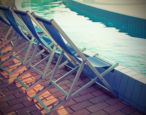 espreguiçadeiras junto à piscina do spa
 - Foto, Imagem