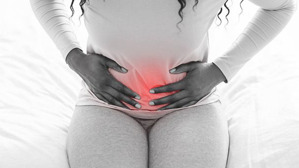 Schwarz-Weiß-Bild einer an Bauchschmerzen leidenden Frau - Foto, Bild