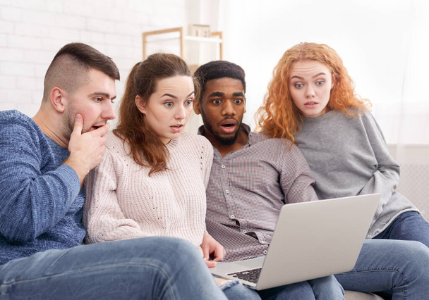Shocked friends watching something on laptop at home - Photo, Image